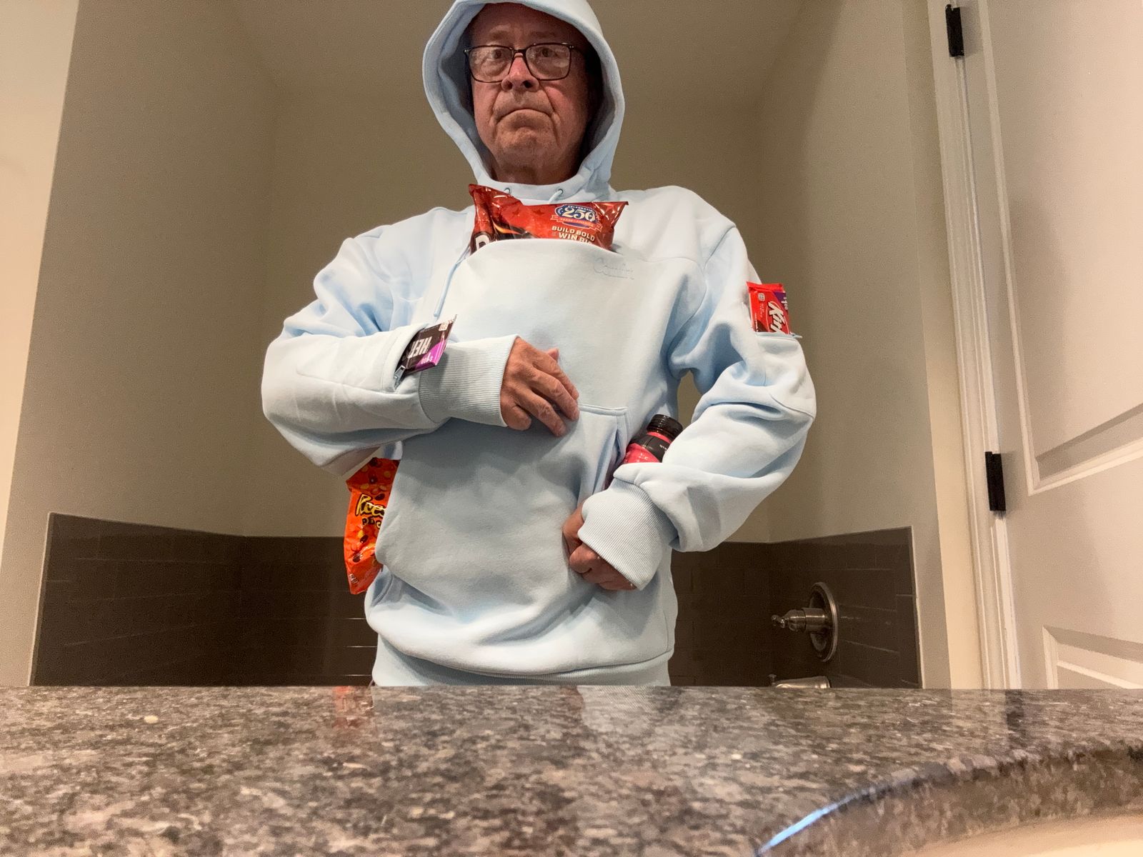 Christopher T. wearing a Baby Blue Snak Hoodie with snacks in its pockets