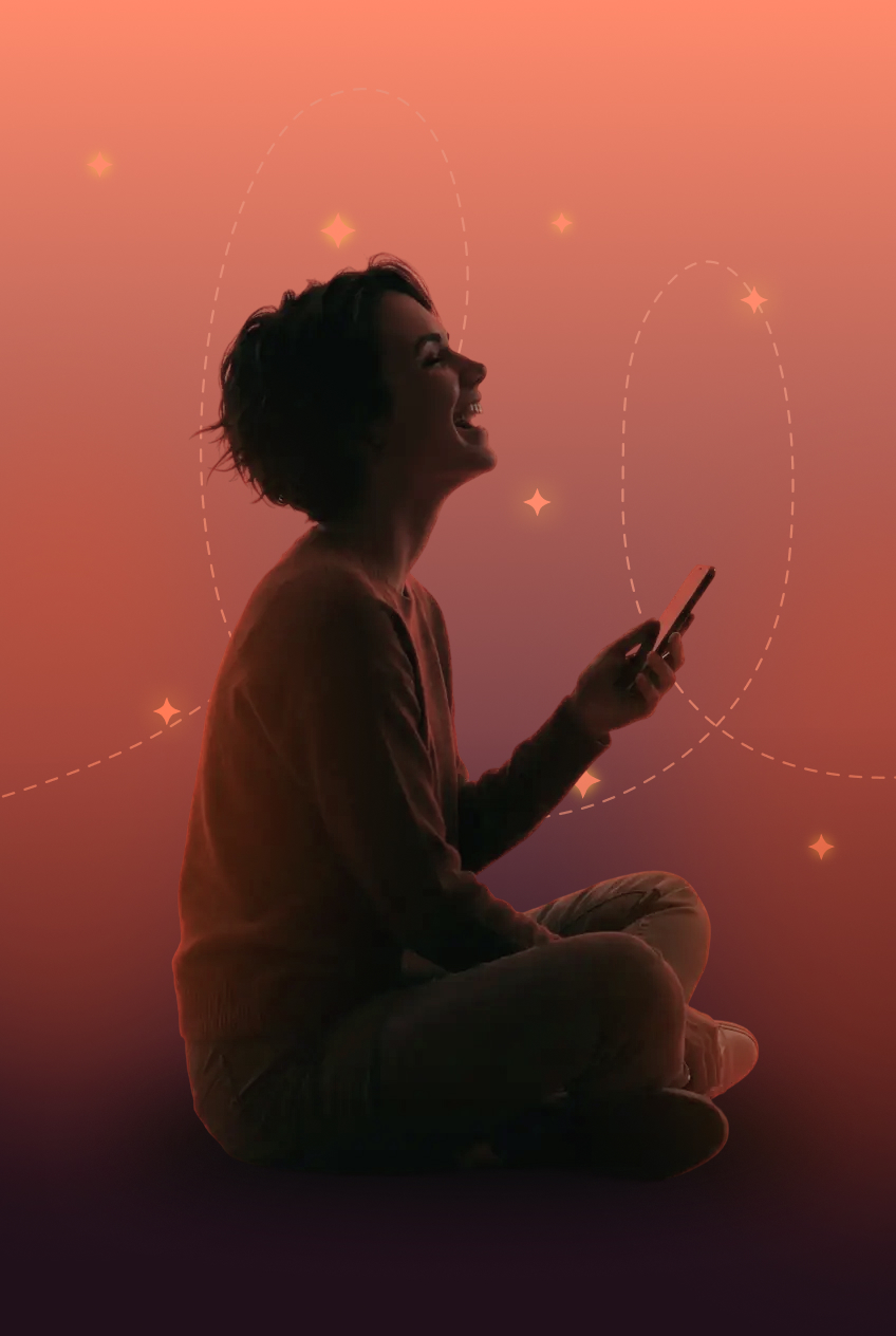 Silhouette of a person sitting cross-legged and holding a phone against an orange background.