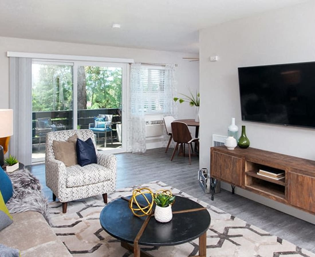 Living area with sofa, tv, coffee table and view of balcony