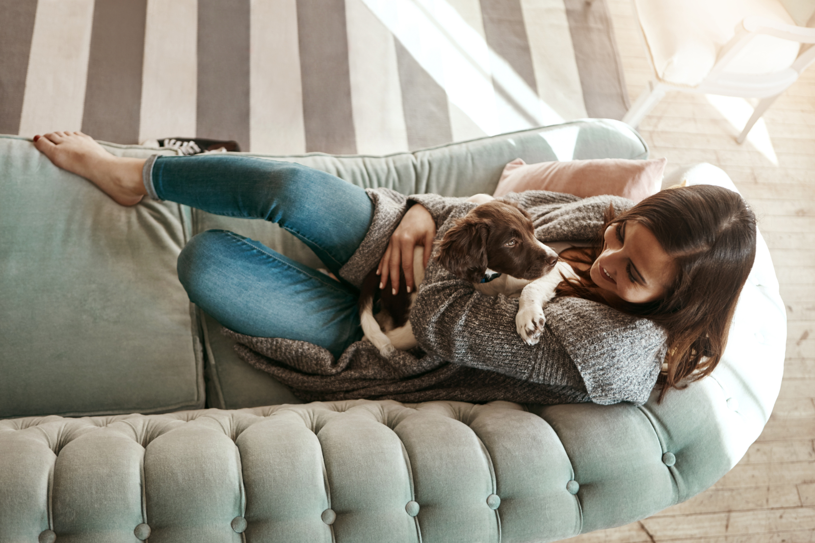 Woman with dog on sofa stock image