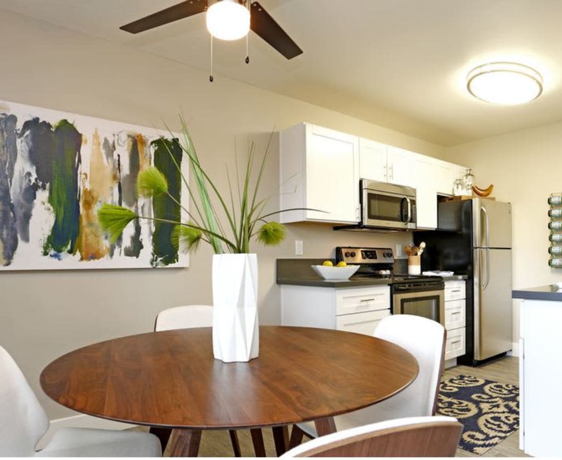Dining area with table and chairs and view into kitchen