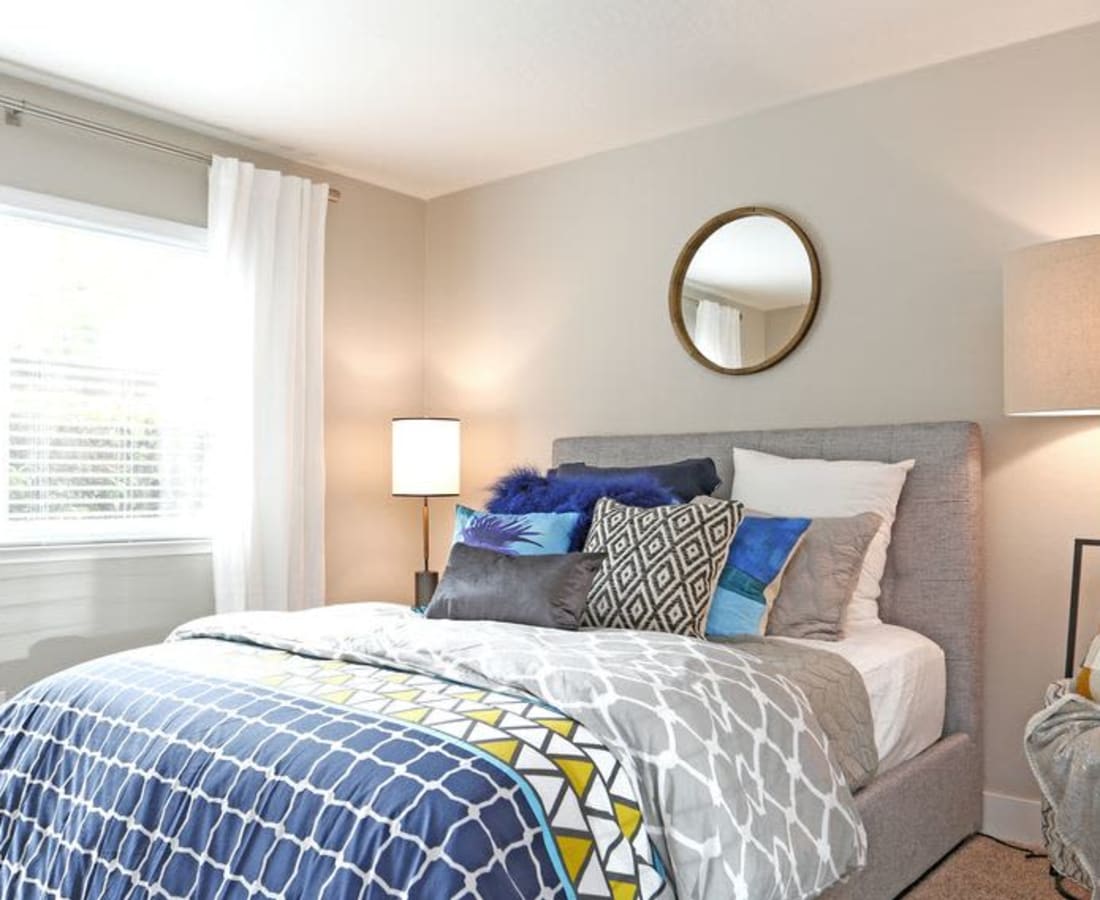 Bedroom with bed, wall mirror and large window