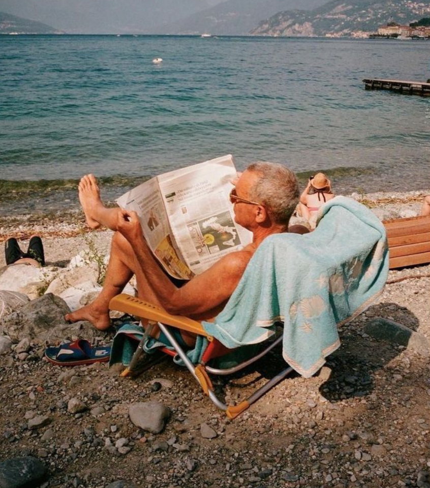 Smiling elderly couple touching foreheads outdoors on a sunny day.