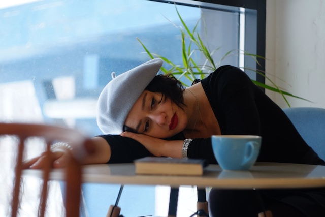 A woman lying down with her head on the desk