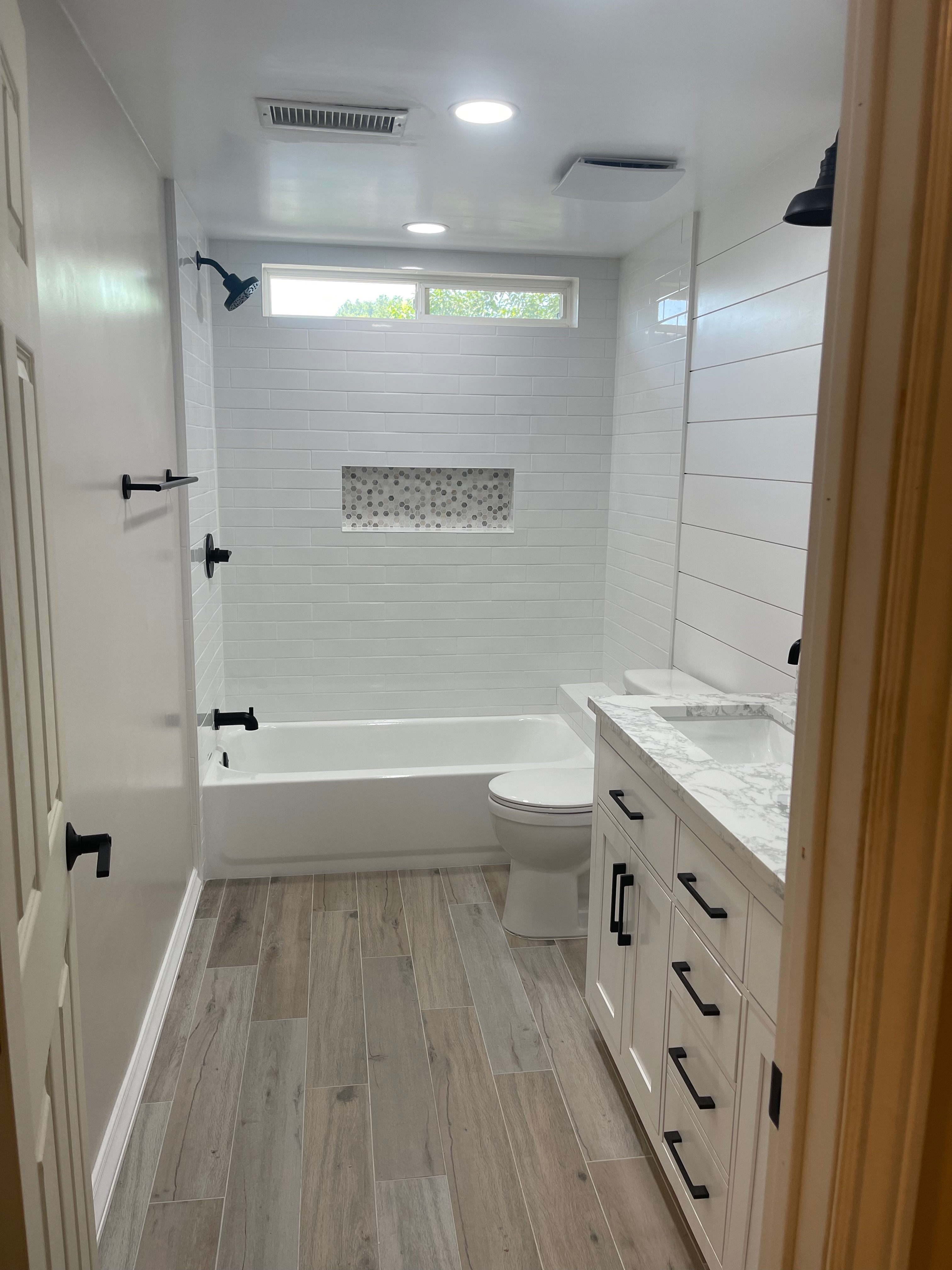 white subway tile bathroom remodel with wood-look flooring, Orange County