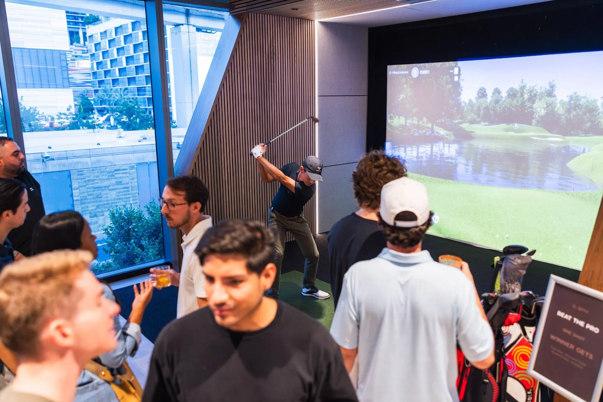 Players taking shots in a Trackman bay at The Tips Golf