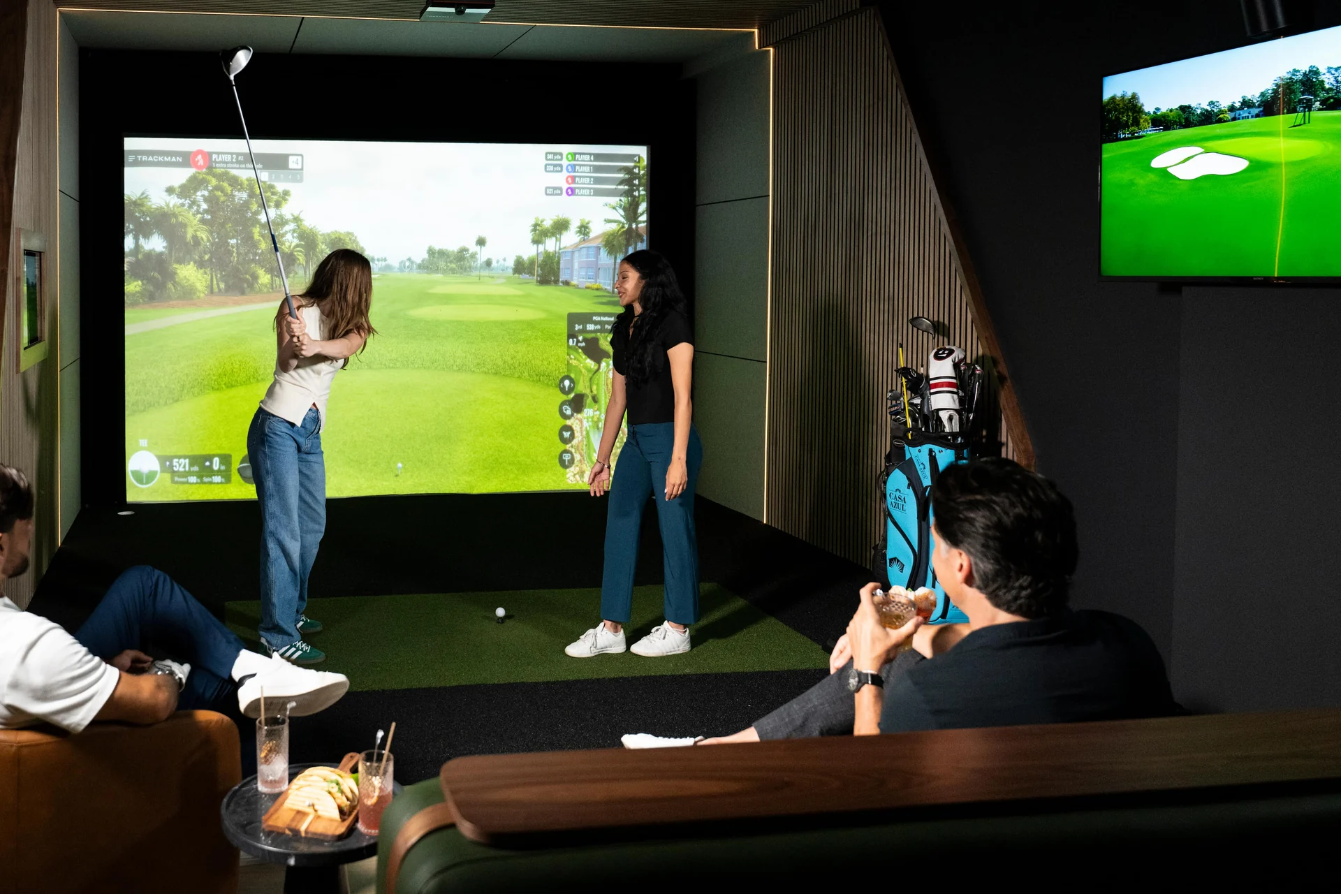 Women playing golf in a Trackman bay at The Tips Golf in Brickell