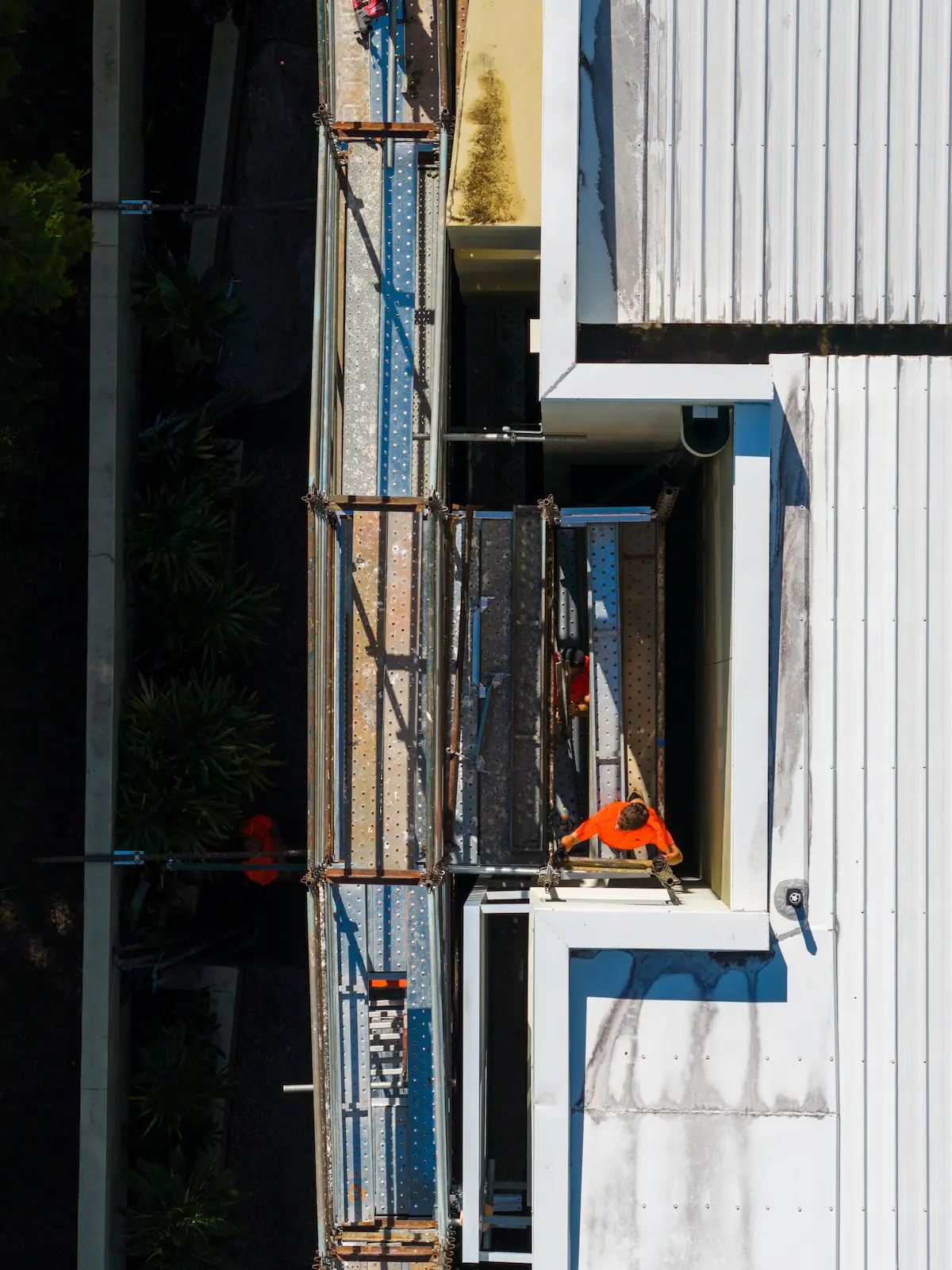 IMP Group painter on scaffolding during exterior repaint of a strata building