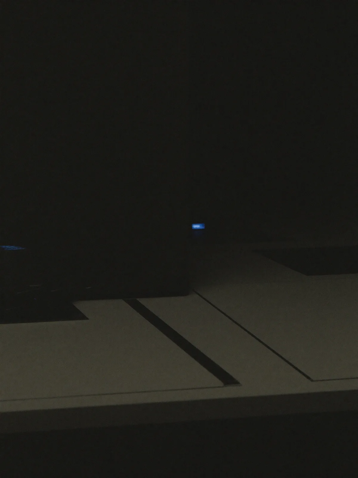 Abstract dark planes and surfaces with a single subtle electric-blue accent light, minimal and precise
