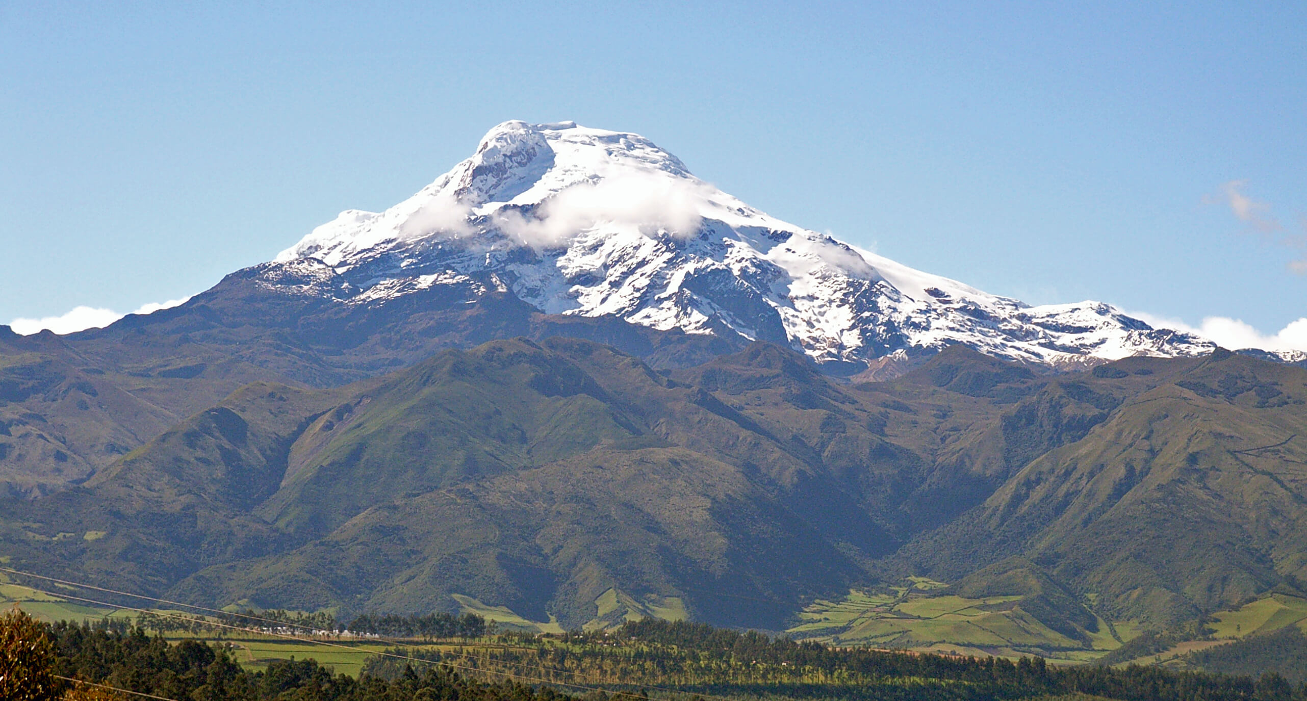 Andean mountain landscape photography for La Divina Papaya by Lunalunares, featuring a snow-capped Ecuadorian mountain rising above green valleys under a clear blue sky.