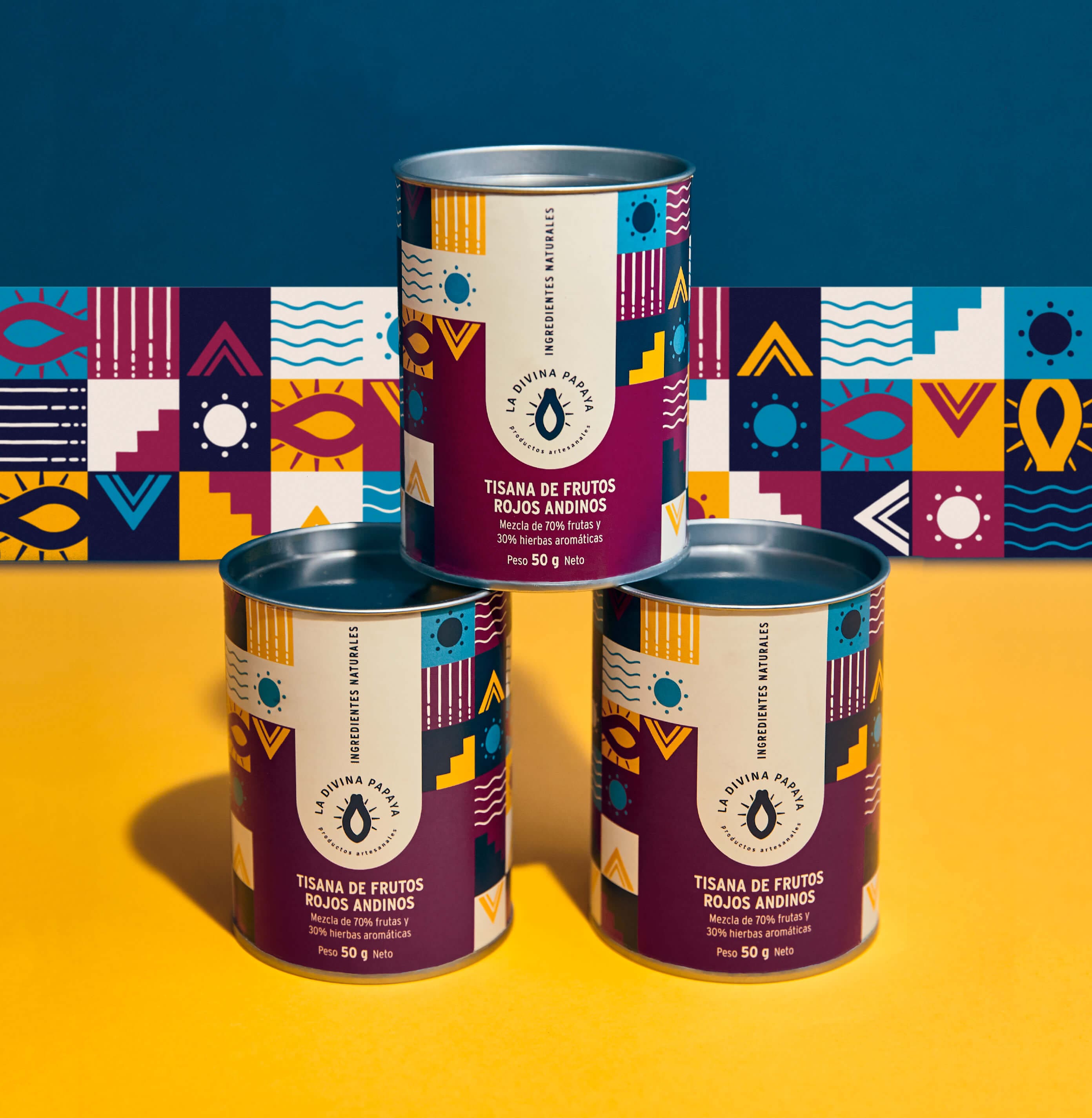 Herbal tea tin packaging for La Divina Papaya by Lunalunares, featuring stacked cylindrical tins with bold patterned labels, colorful product design, and a vibrant yellow and blue studio composition.