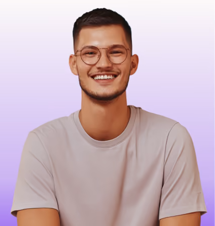 Smiling man wearing glasses and a light gray t-shirt with a purple gradient background.