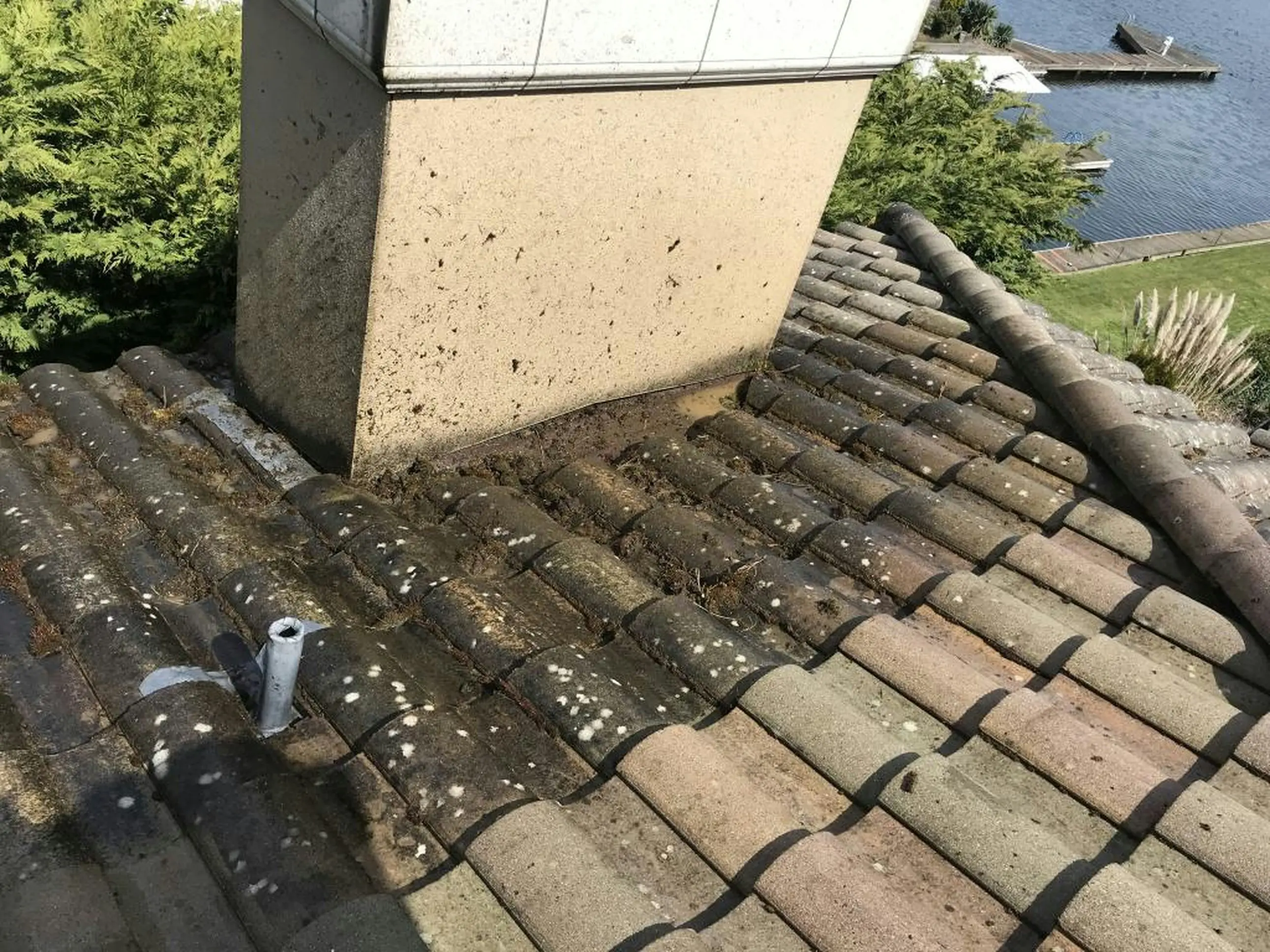 Toiture tuiles dégradée avec mousse et débris autour de la cheminée risque de fuite La Baule SDR HABITAT