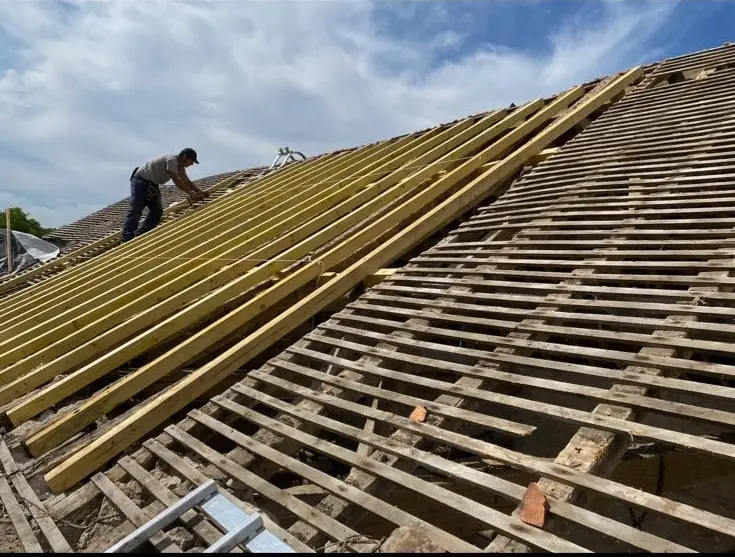 Couvreur en train de poser des liteaux neufs lors d'une rénovation de toiture à La Baule – charpente et couverture Loire-Atlantique