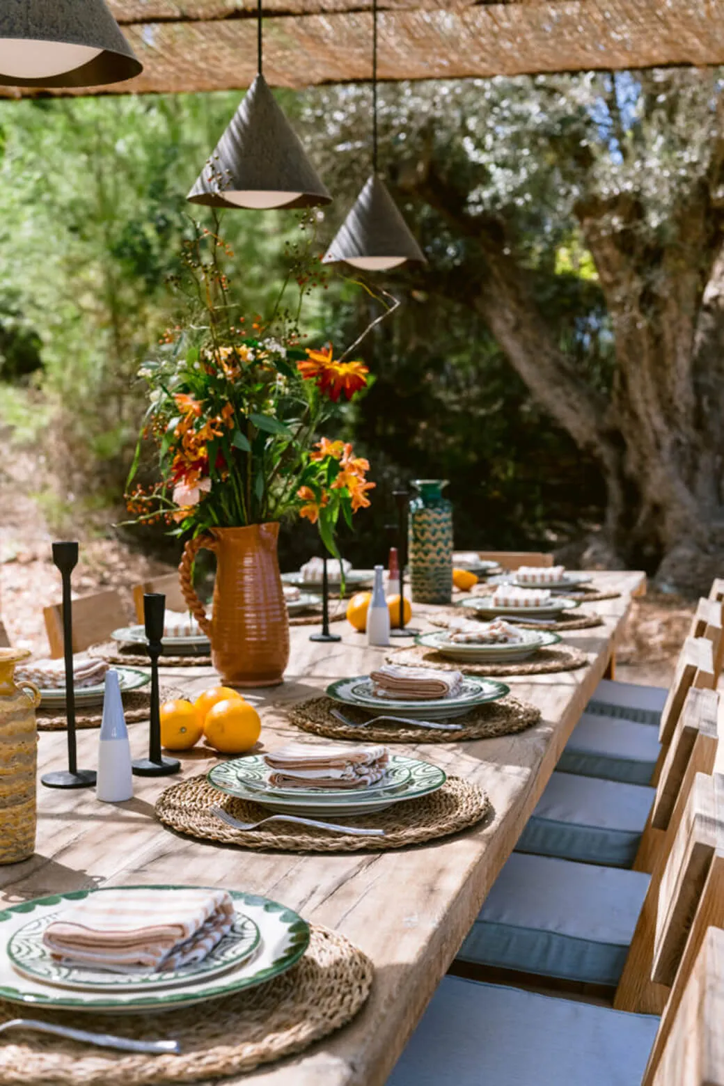 Luxury outdoor dining table styling at Villa Benimussa in Ibiza, featuring rustic tableware, natural linen, and fresh summer florals.