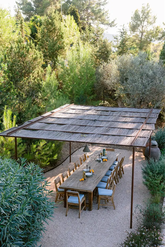 Bird's-eye view of a luxury outdoor dining pergola architecture at Villa Benimussa in Ibiza, surrounded by lush Mediterranean landscaping.