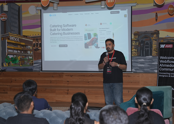 Man giving a presentation on catering software to an audience in a conference room.
