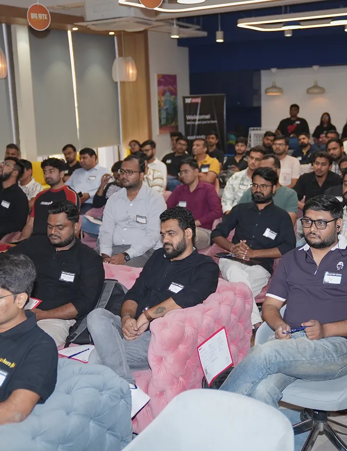 A group of men attentively seated in a conference room attending a presentation or workshop.