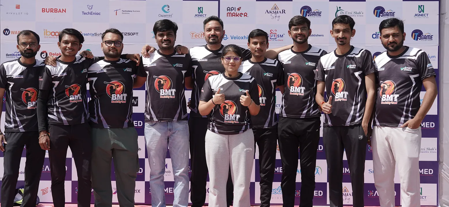 Group of people in matching black and white BMT sports jerseys posing with thumbs up outdoors.