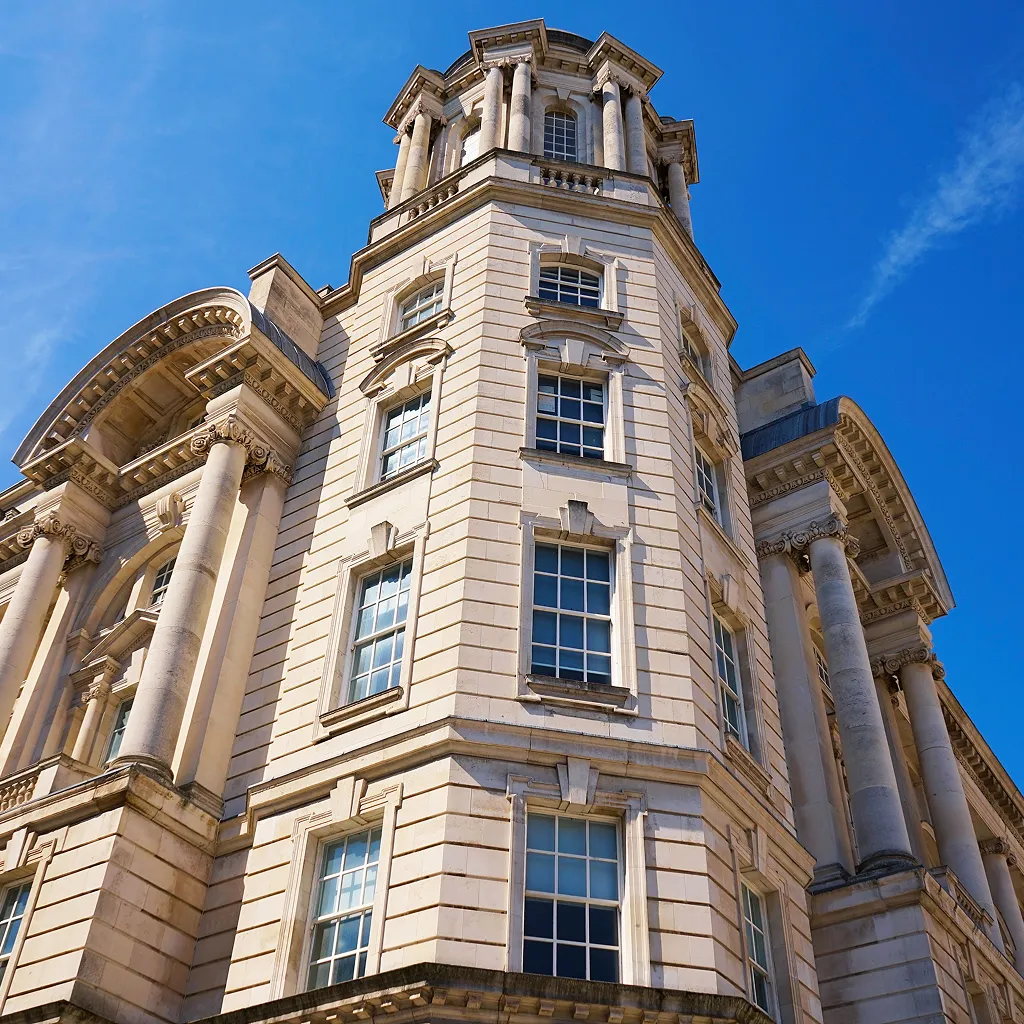 Low angle view of a classical public sector building with columns and blue sky background.