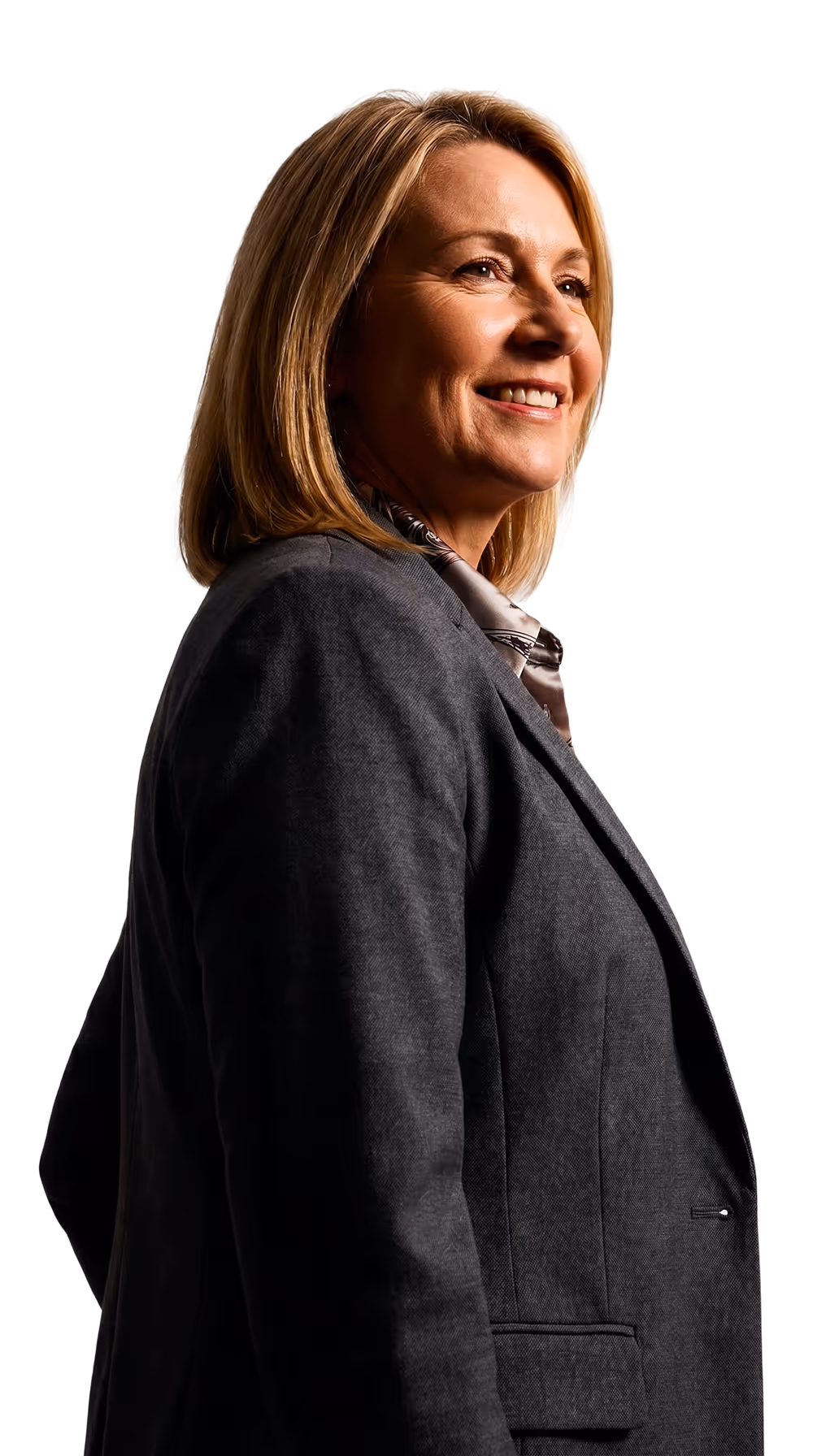 Confident middle-aged woman smiling, wearing a gray blazer and looking slightly upward to the right.