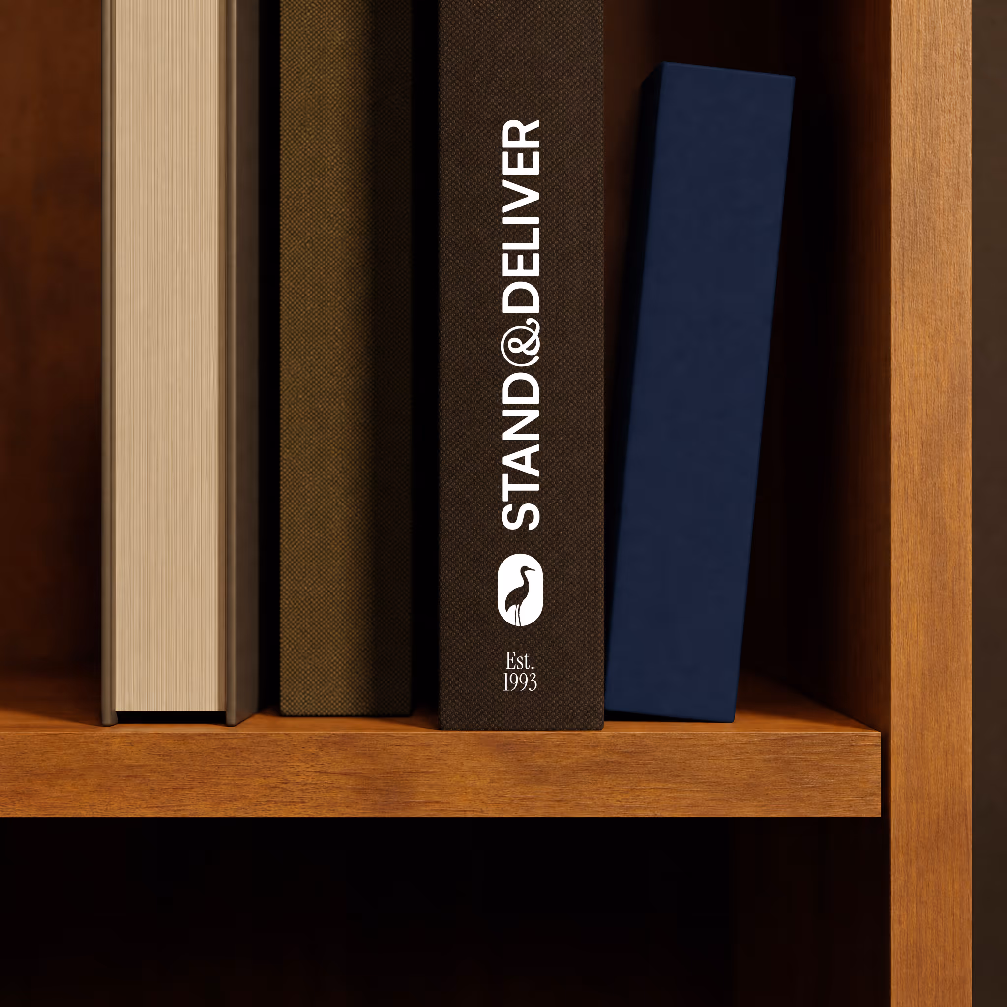 Books on a wooden shelf including one with a cover reading STAND&DELIVER Est. 1993.