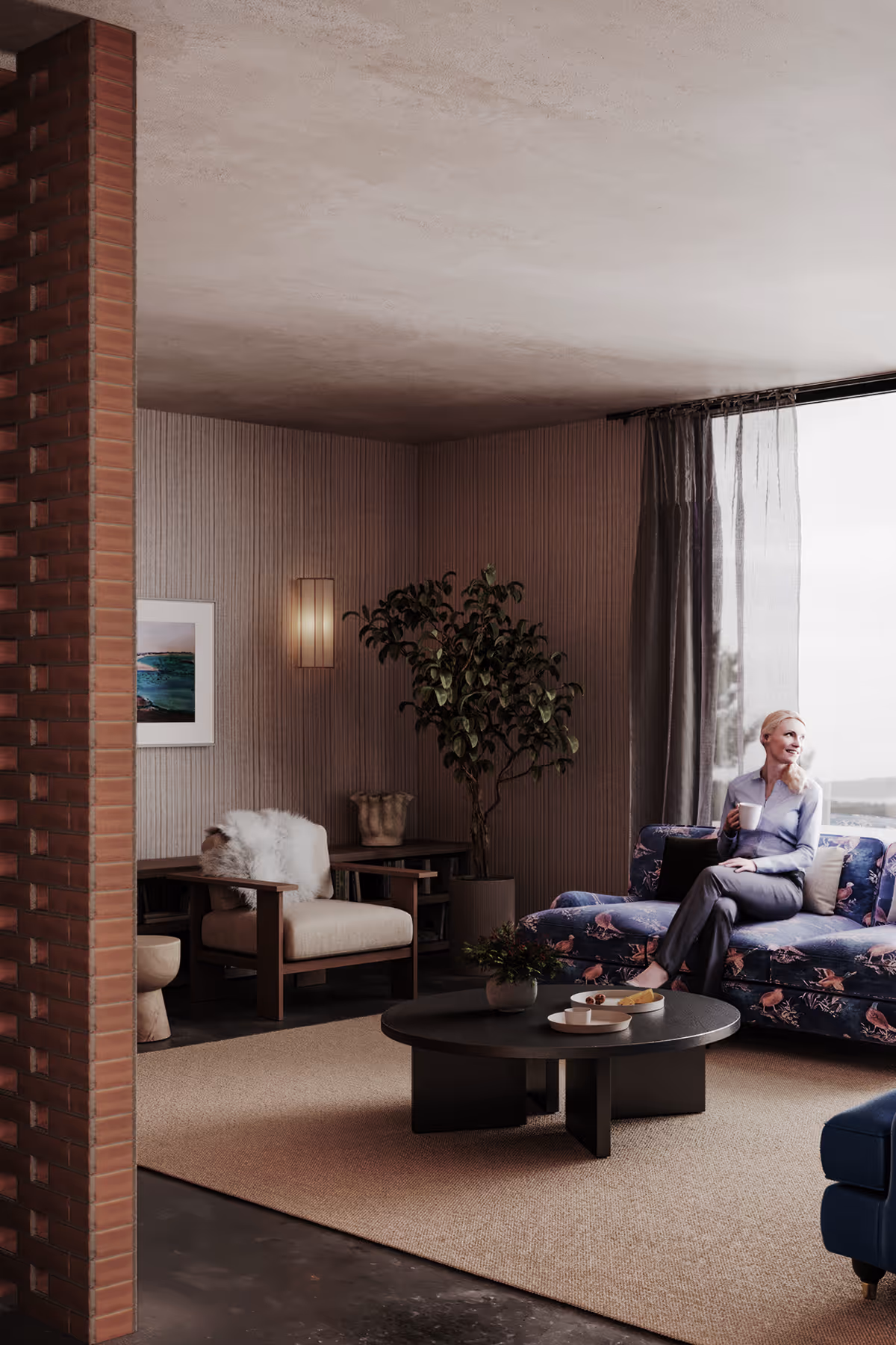 Woman sitting on a floral sofa holding a cup in a modern living room with a coffee table and armchair.