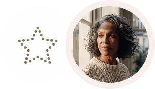Woman with curly hair wearing a beige sweater, looking thoughtfully out a window.