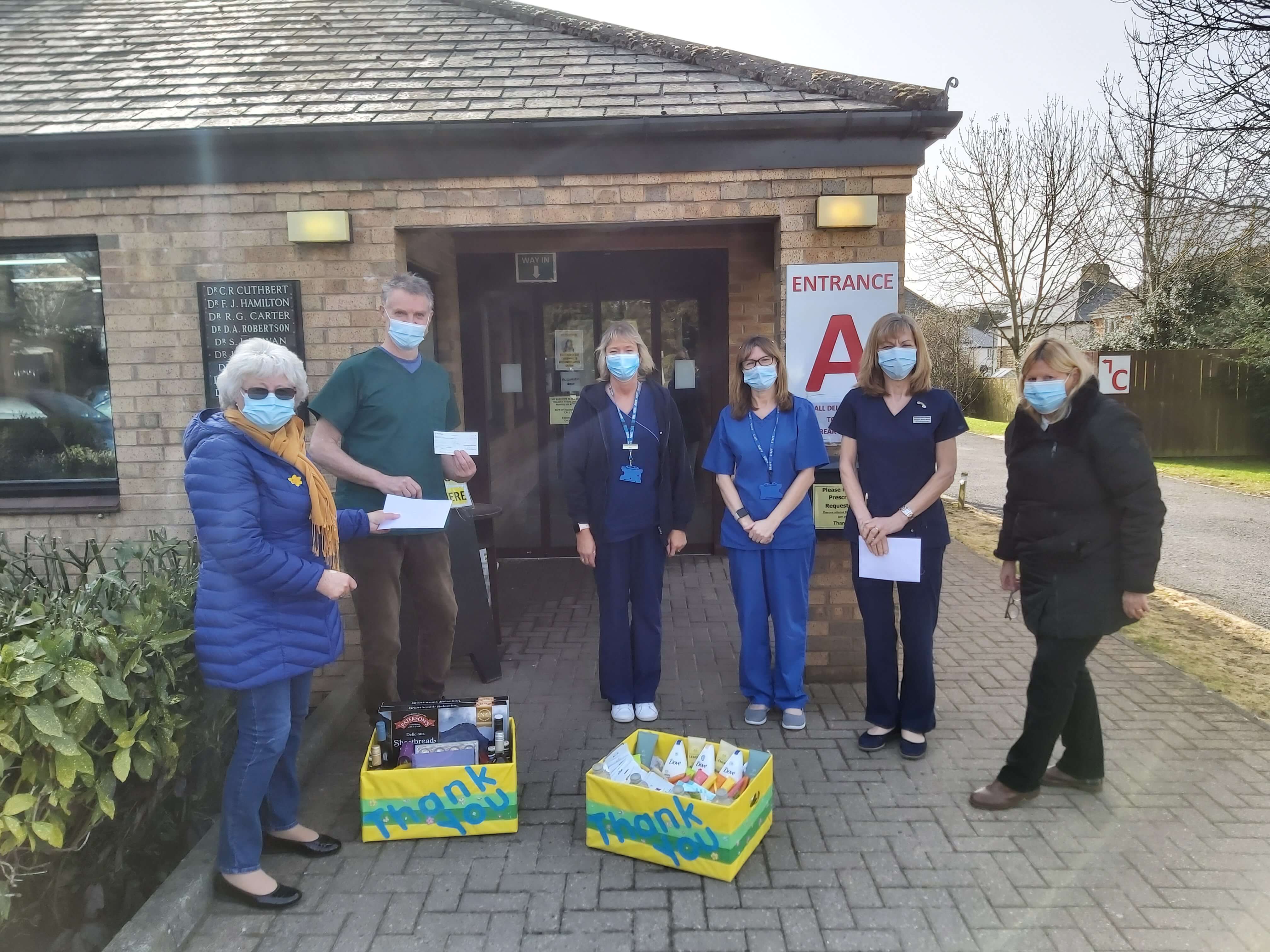 Outside the Surgery. Miriam Fenwick delivers a donation.