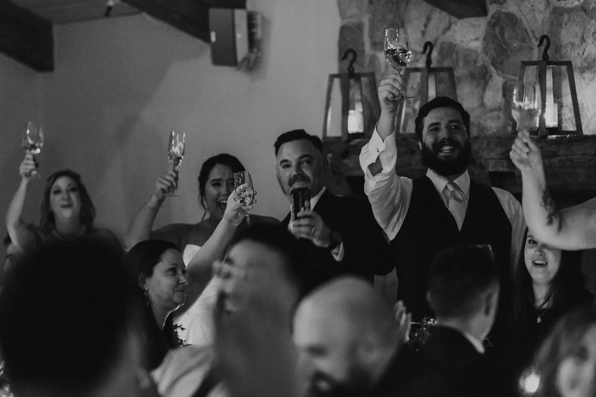 Bride, groom, and guests raising a toast during the wedding reception at Pepperrell Cove in Kittery, Maine, celebrating an intimate coastal wedding.