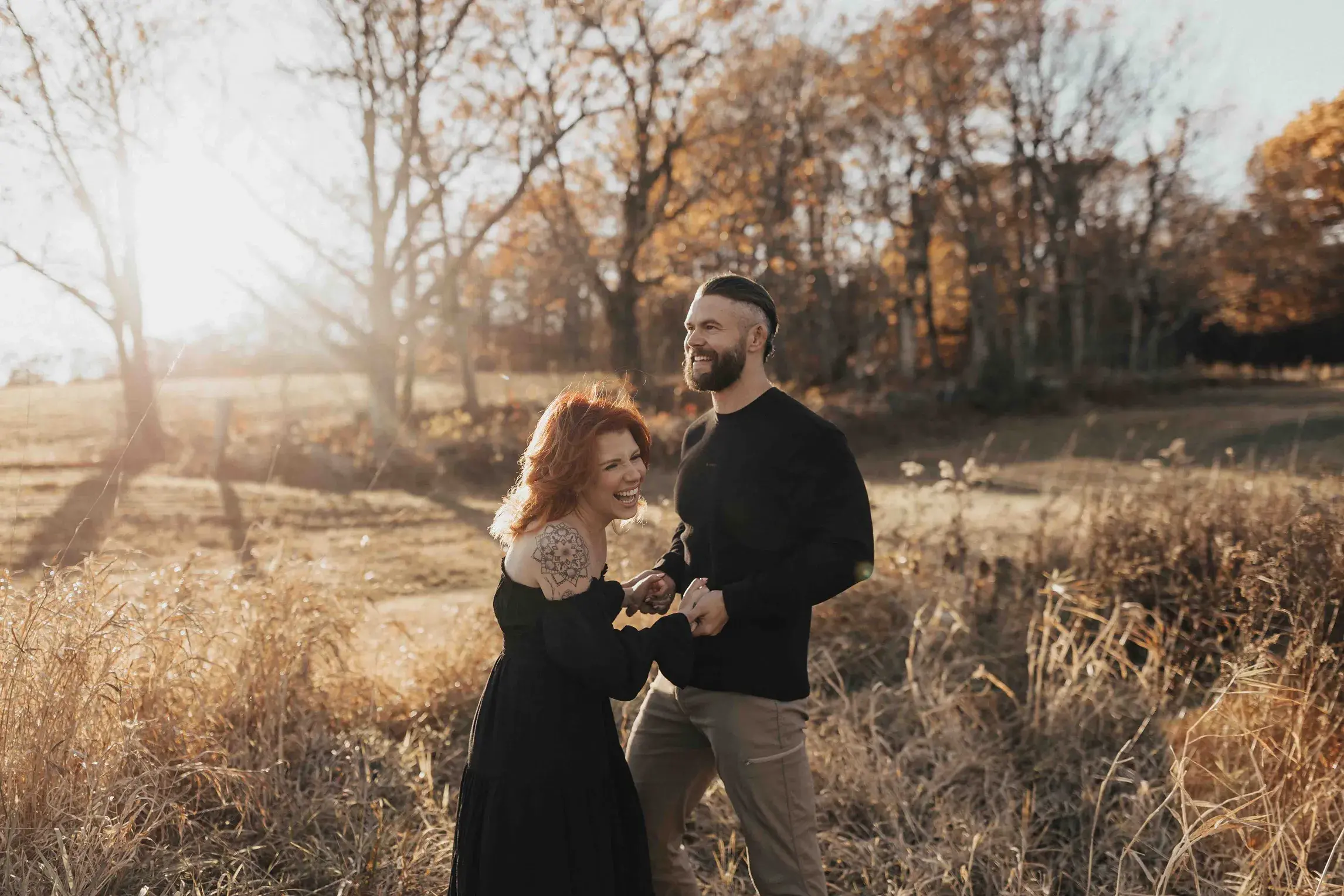 Couple laughing together during a fall engagement session at Jewel Hill in Ashburnham, surrounded by golden autumn light and colorful foliage.