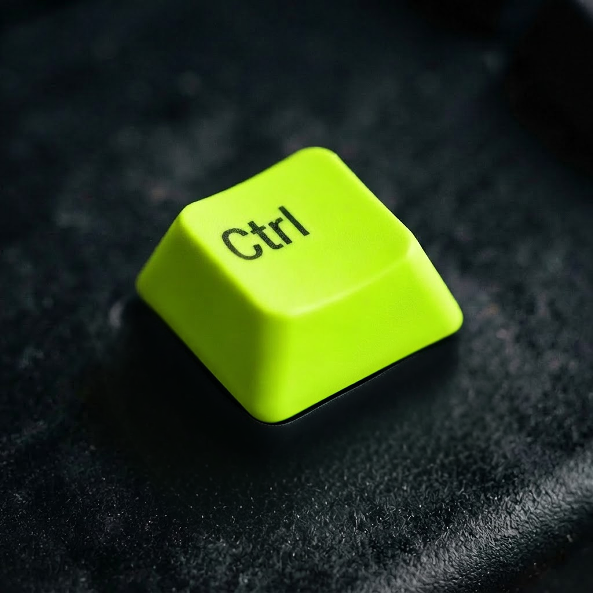 Lime-green Ctrl keycap on a dark textured surface.