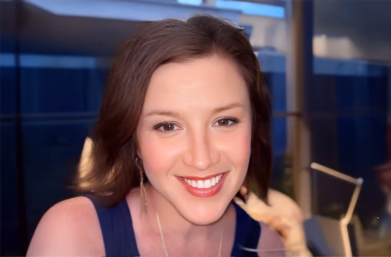 Smiling woman with brown hair photographed indoors.