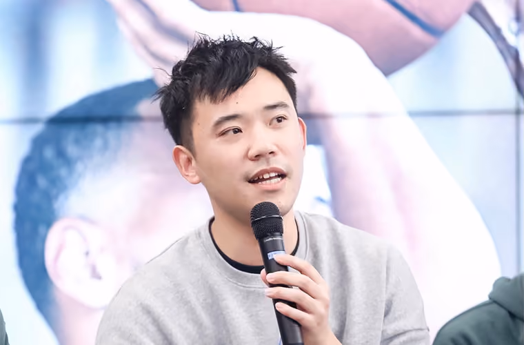 Man speaking into a microphone at a panel event.
