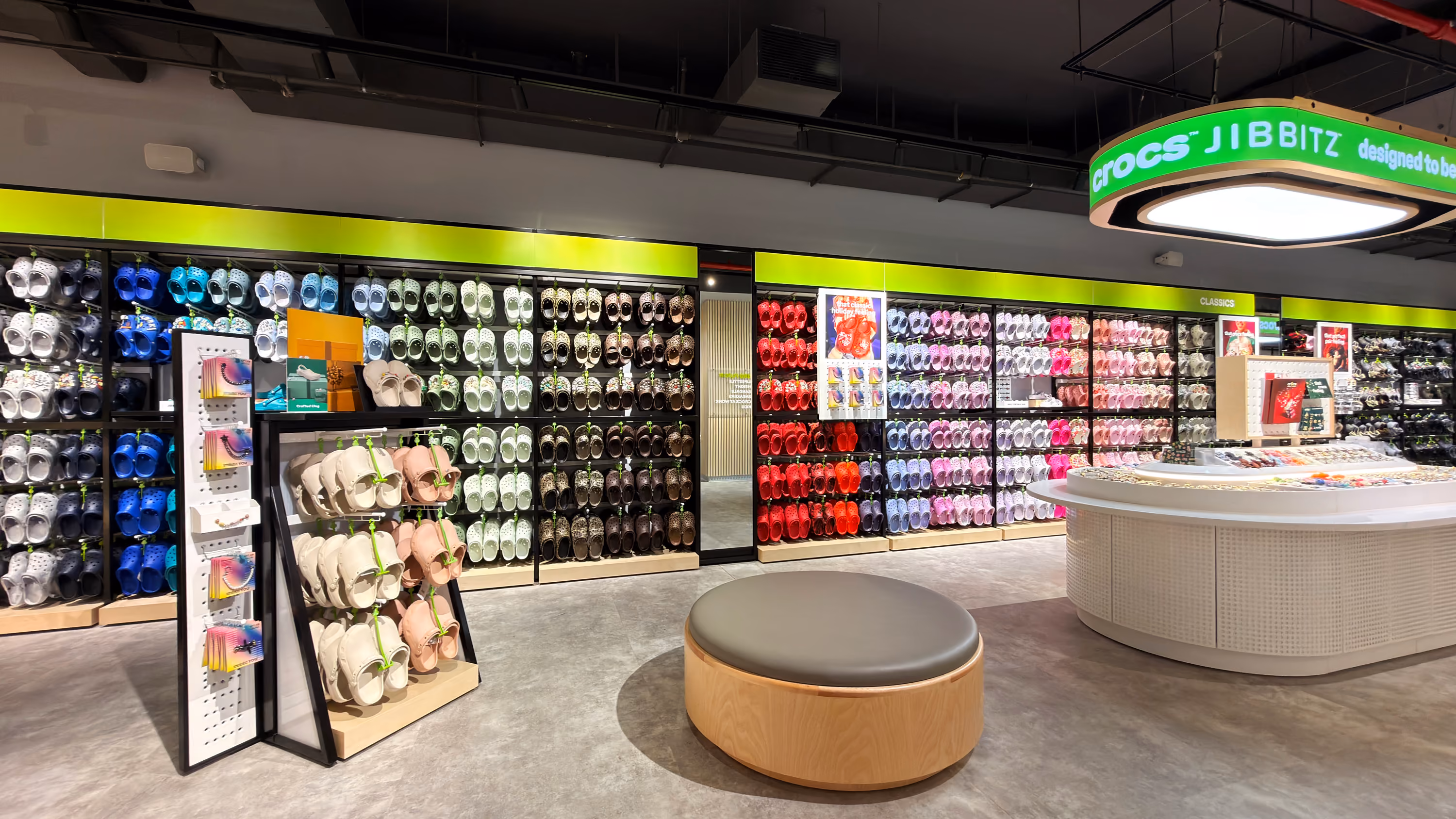 Crocs retail store display featuring shoes and colorful Jibbitz charms.