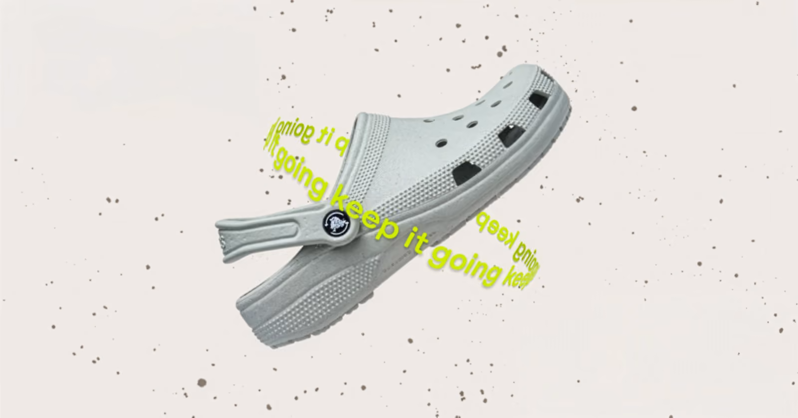 Gray Crocs Keep It Going Clog with heel strap against a graphic background.