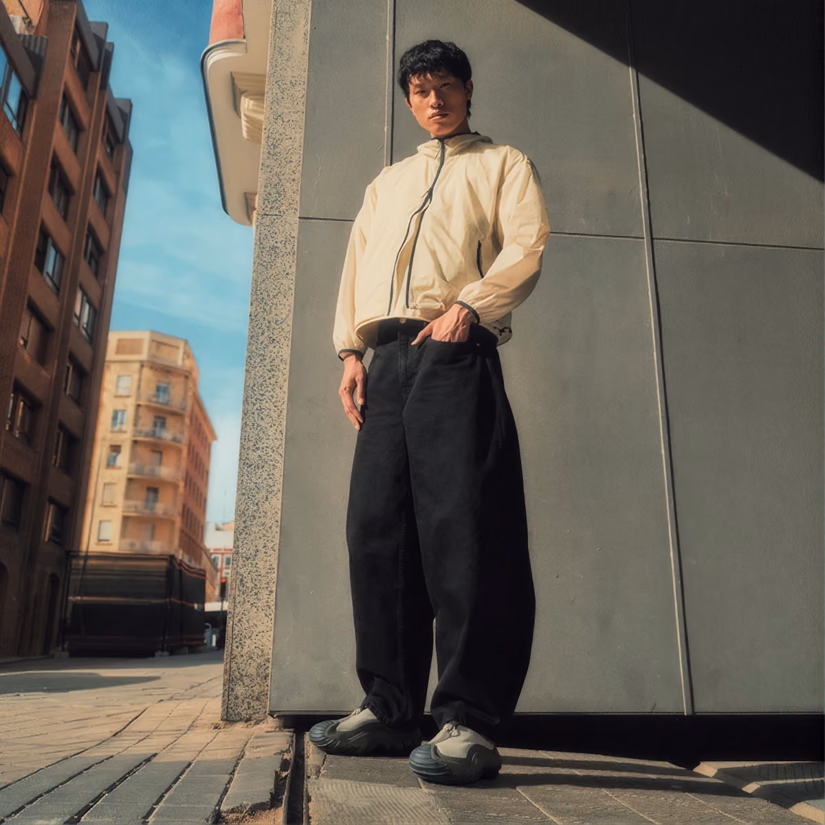 Person standing on a city street wearing dark Crocs clogs.