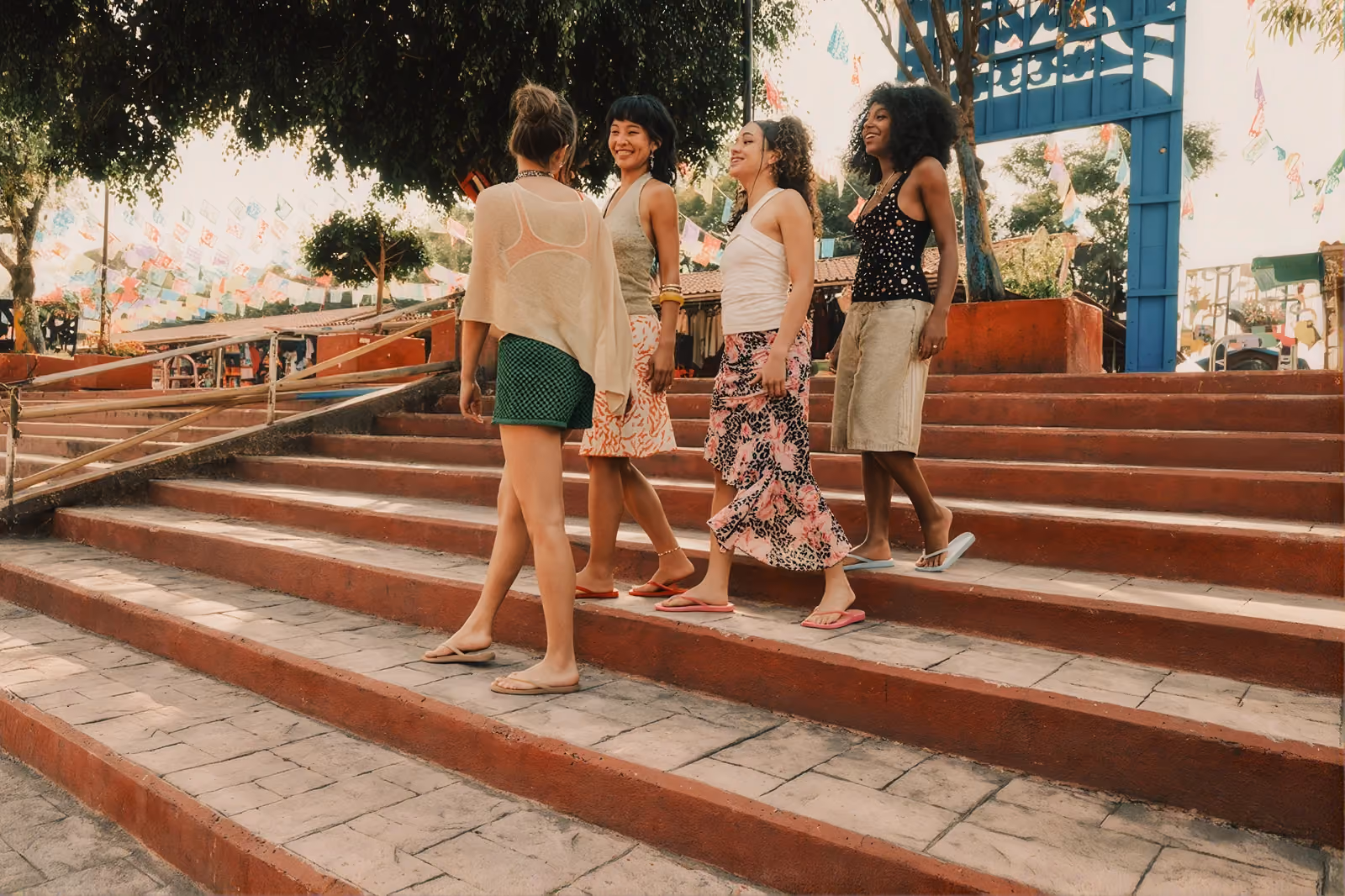 Four friends chatting on colorful outdoor steps.