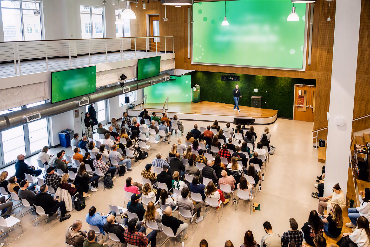 Audience watching a presentation in a large auditorium.