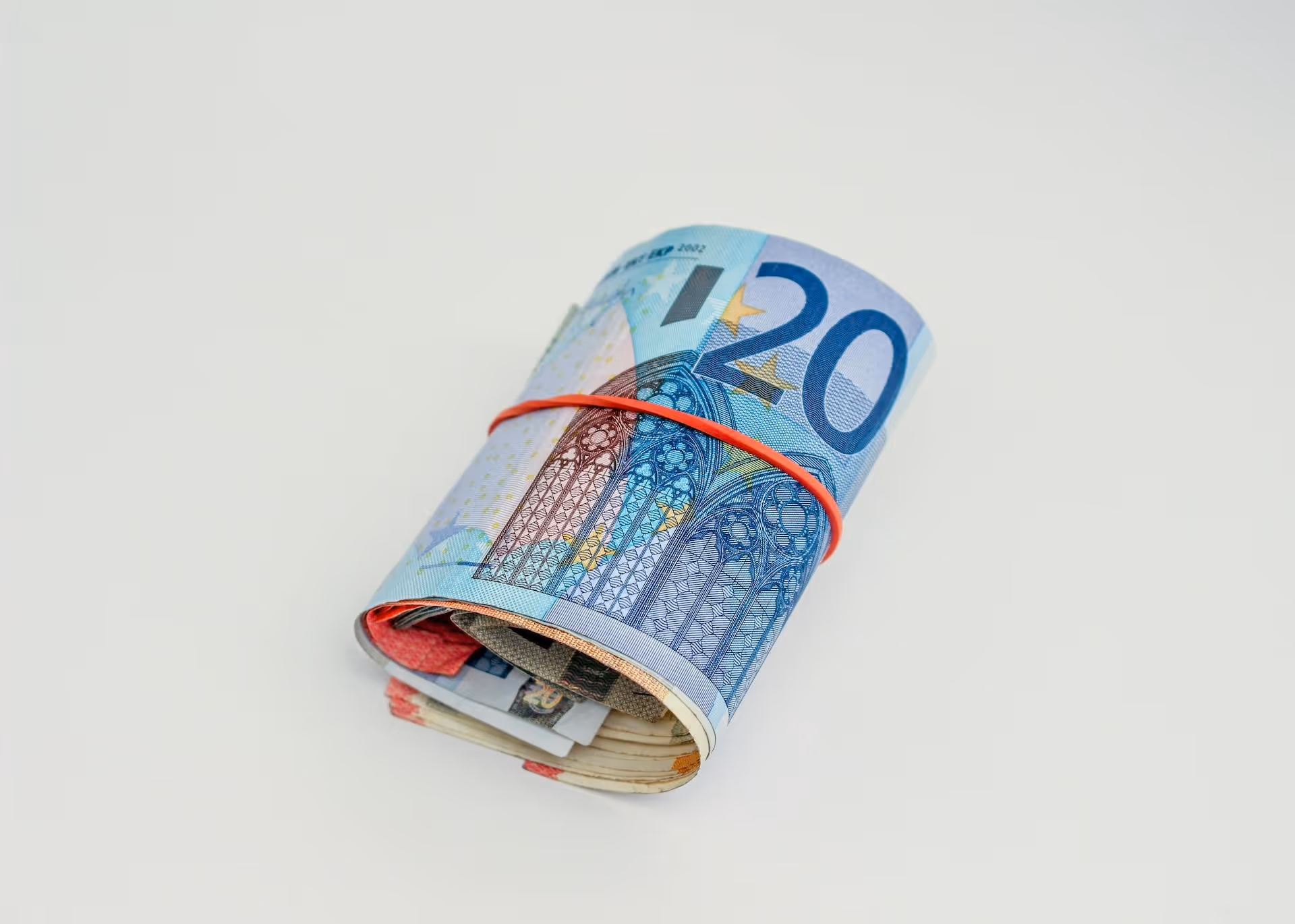 Rolled up 20 euro banknote held together with red rubber band