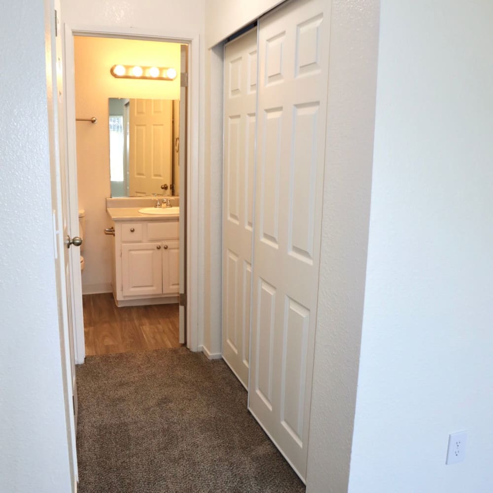 Hallway to bathroom with white cabinets