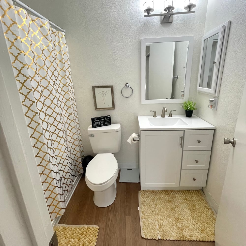 Bathroom with shower, white cabinets, and vanity