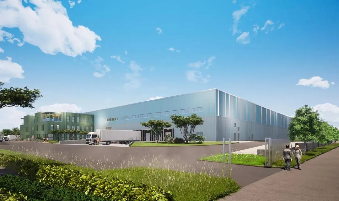 Modern industrial warehouse with loading dock, landscaped grounds, and pedestrian walkway.