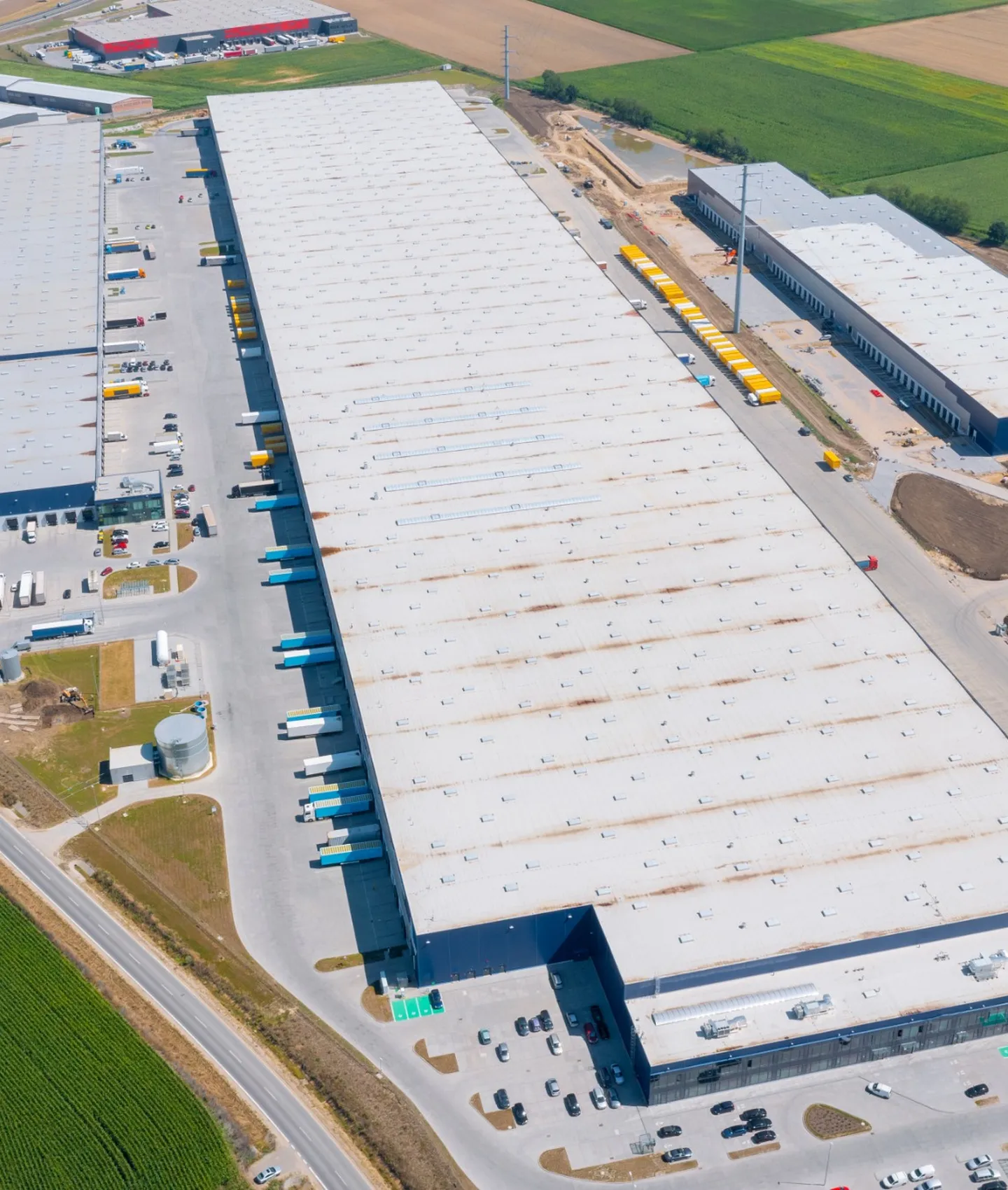 Aerial view of a large industrial warehouse and distribution facility surrounded by farmland.