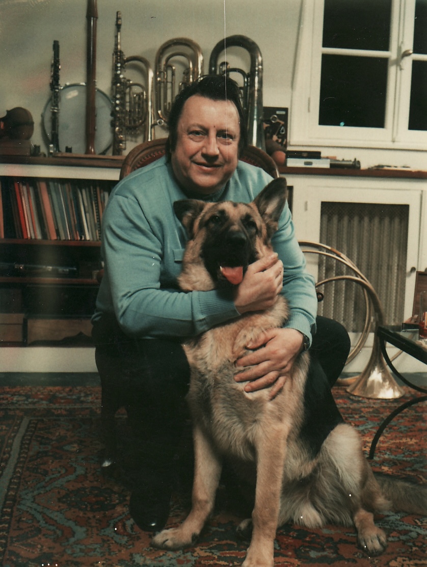 Raymond Devos dans son grenier avec un de ses chiens, 1973