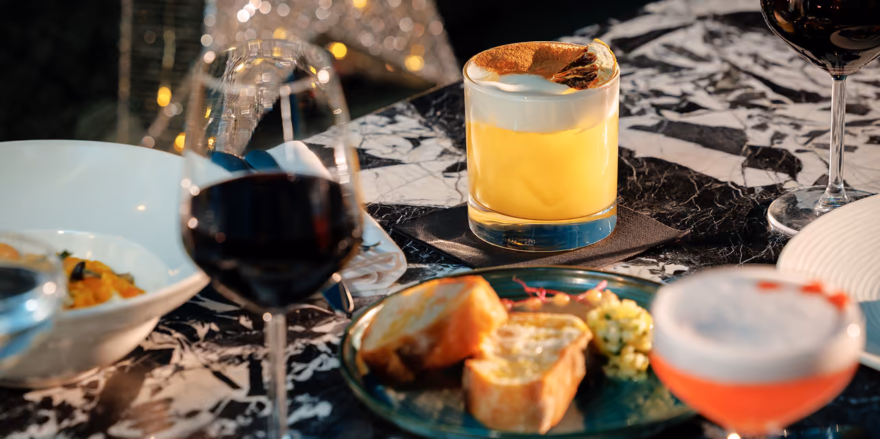 Festive cocktails, wine and sharing plates on a marble table at The Grayson