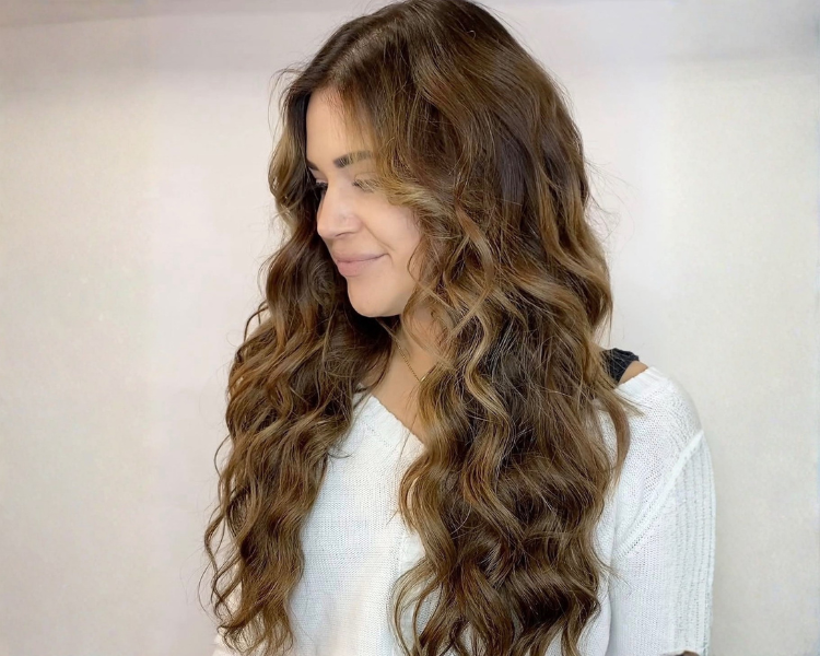 Stylist applying hair extensions at Joan & Co. Mankato