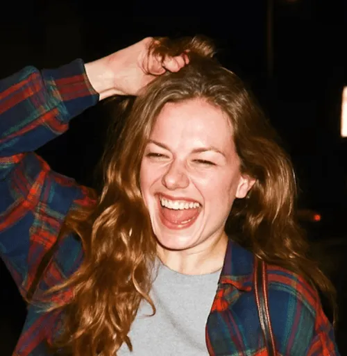 Photo of a laughing woman in a plaid shirt