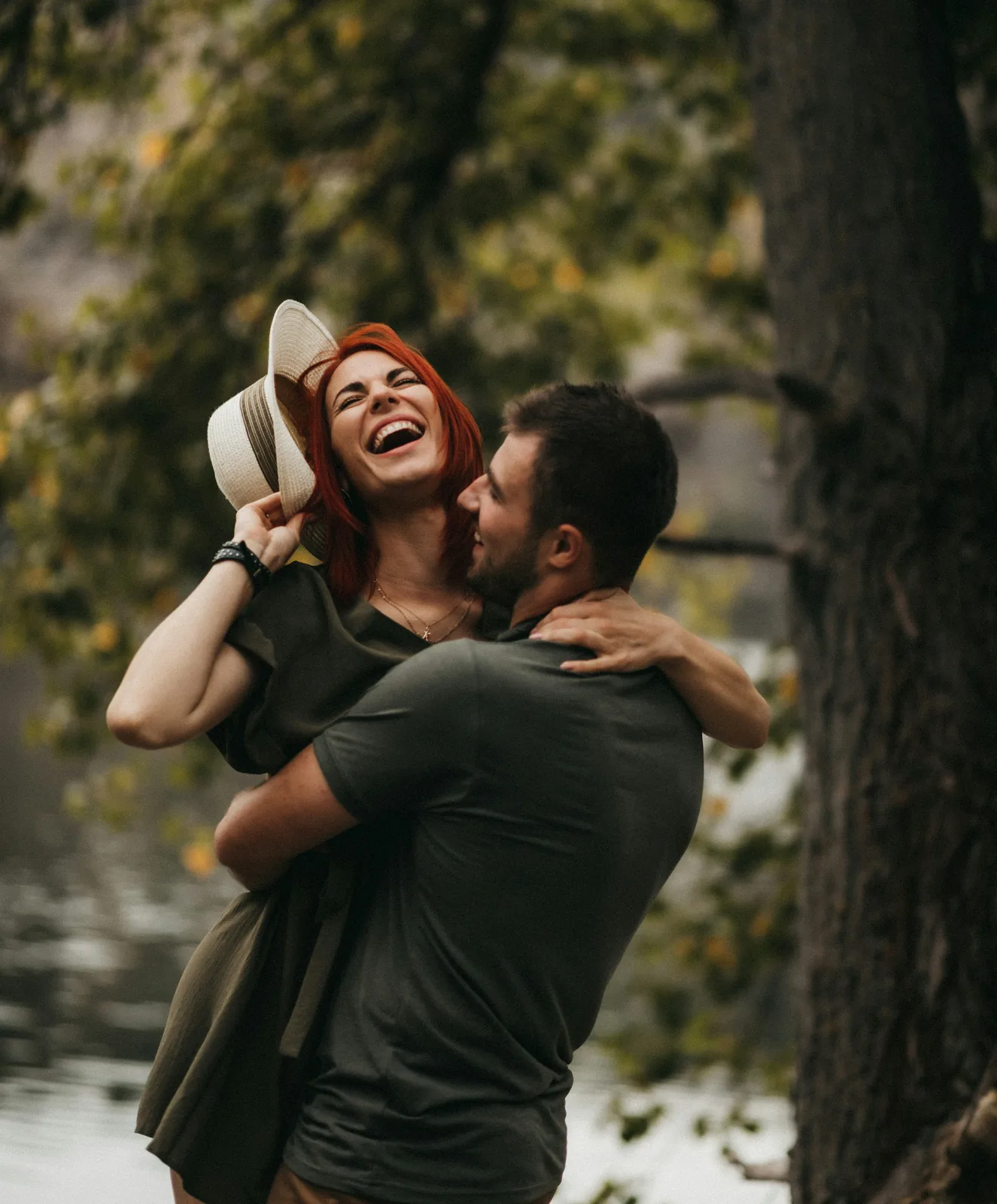 Photo of a laughing couple embracing under a tree