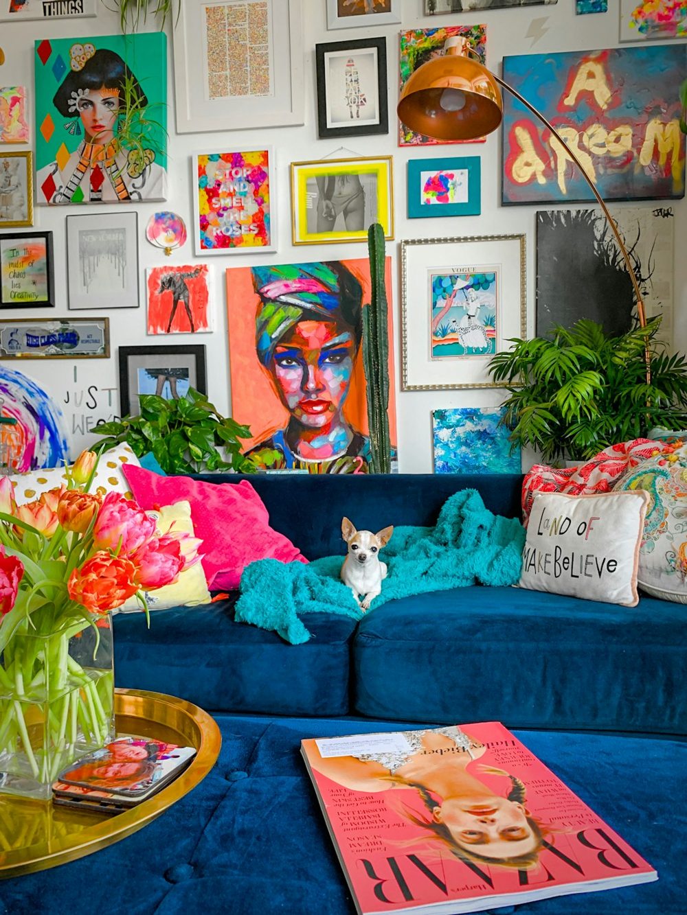 A living room with a blue couch and lots of pictures on the wall